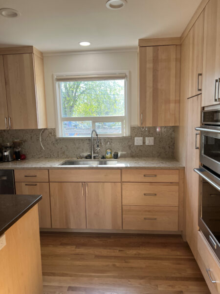 Oak floors, quartz countertops, wood cabinets, natural light, quartz backsplash, open kitchen